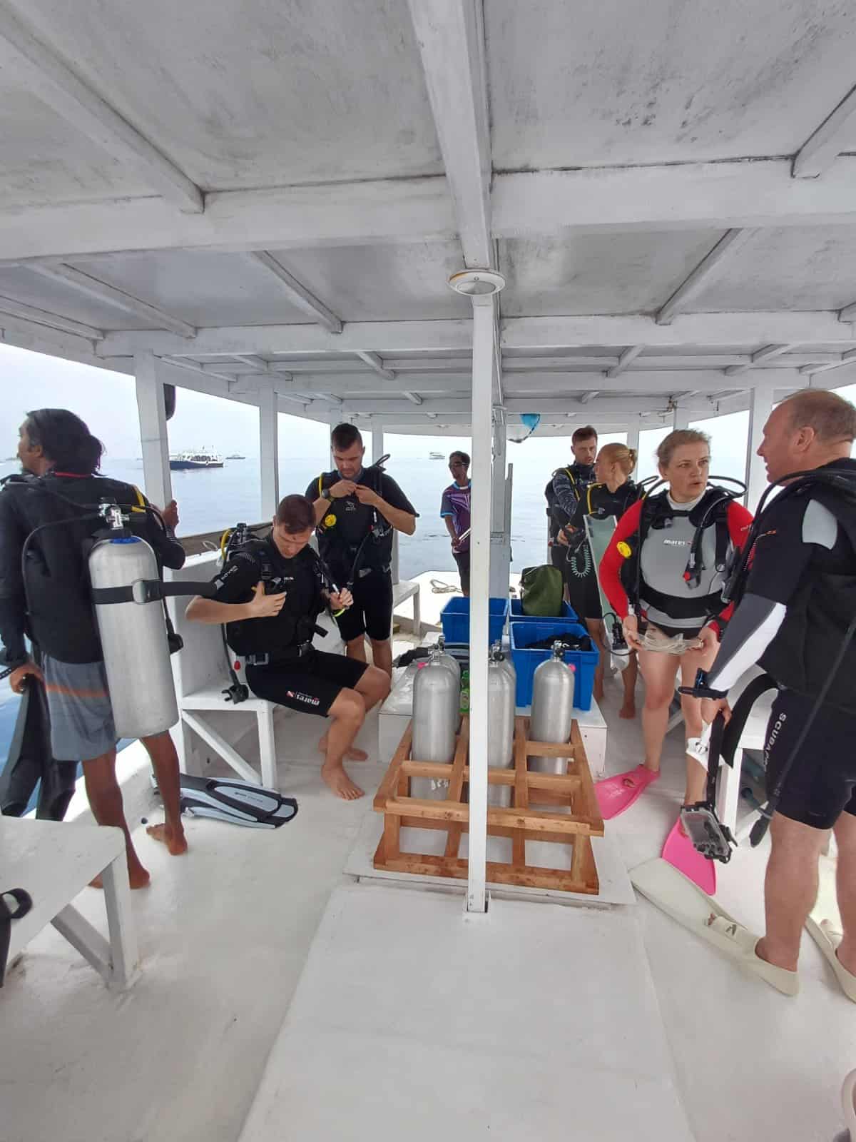 Divers descending onto a coral reef in Rasdhoo Atoll